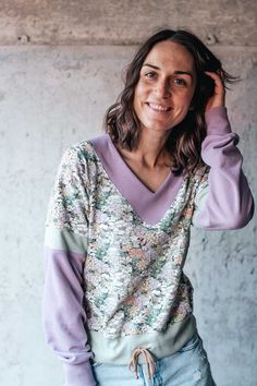 a woman with long hair wearing a sweater and jeans