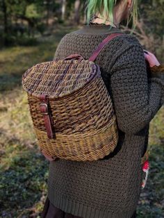 a woman with green hair carrying a wicker backpack