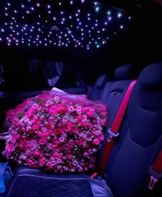 pink flowers in the back seat of a car with blue seats and lights above it