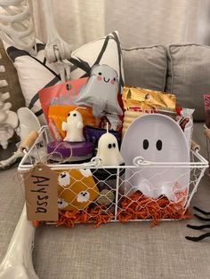 a basket filled with halloween treats on top of a couch