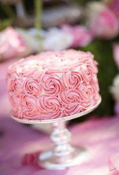 a pink cake sitting on top of a glass plate next to flowers and text that reads instagram