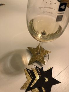 a glass of wine with some gold stars on the side and another one in the middle