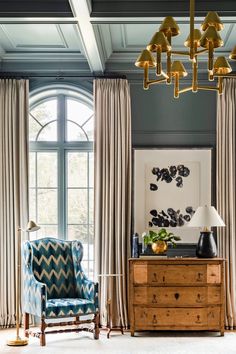 a living room filled with furniture and a chandelier hanging from the skylight