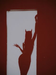 the shadow of a woman holding onto a door