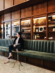 a woman is sitting on a bench in the lobby