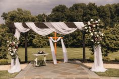 an outdoor wedding setup with white drapes and flowers