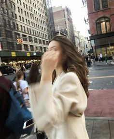 a woman walking down the street talking on her cell phone