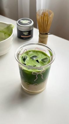 a cup with green liquid in it sitting on a table