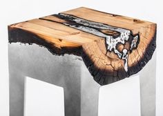 a piece of wood that is on top of a metal stool with an abstract design