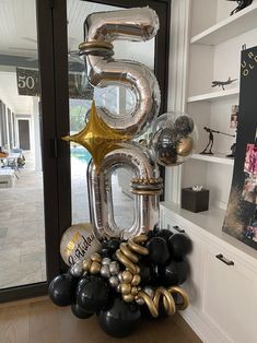 the balloon number 50 is displayed in front of a door with balloons and other decorations