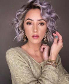 a woman with grey hair and leopard print earrings is posing for the camera, her hand on her shoulder