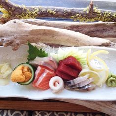 a white plate topped with assorted sushi and other foods on top of it