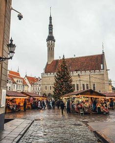 the christmas market is set up in front of an old building with a tall clock tower