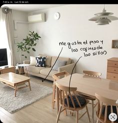 a living room filled with furniture and a wooden table in front of a white wall