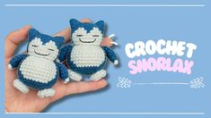 two crochet snowflak cats sitting on top of each other in front of a blue background