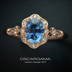 an oval shaped blue and white diamond ring in rose gold with diamonds around the band