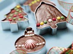 christmas tree shaped cookies in tins on a table