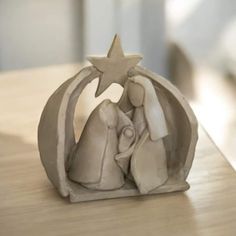 a ceramic nativity figurine with a star on it's head sitting on a table