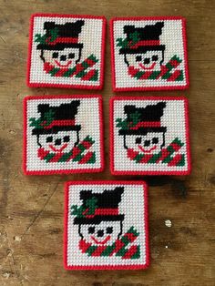 four cross stitch coasters with the image of a man in a top hat on them