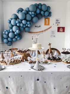 a table topped with blue balloons and desserts