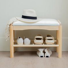 a wooden bench with shoes and a hat on it