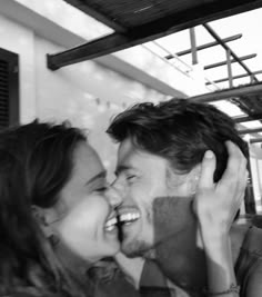 a man and woman are laughing together in black and white