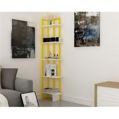 a living room with a gray couch and yellow shelving unit in the corner next to a painting on the wall