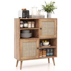 a wooden cabinet with wicker doors and baskets on the bottom shelf, next to a potted plant