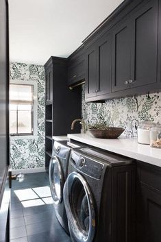 a washer and dryer in a room with black cabinets