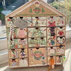 a wooden toy house with christmas decorations on it