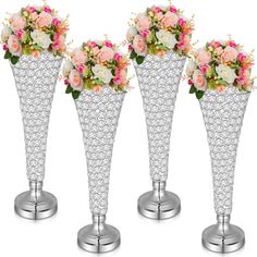 three silver vases with flowers in them on stands against a white background for display