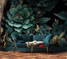 a blue couch sitting in front of a wall with flowers on it's side