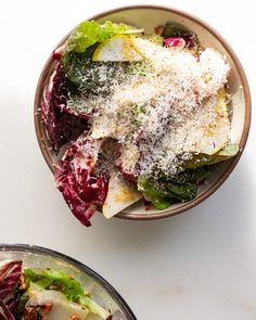 a salad in a bowl with parmesan cheese and lettuce on top