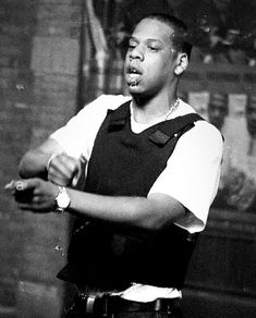 a black and white photo of a young man holding a cell phone in his right hand