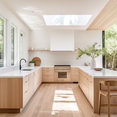 a kitchen with wooden cabinets and white counter tops is shown in this image, while the sun shines through the windows