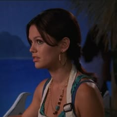 a woman sitting at a table in front of a blue wall with palm trees on it