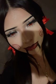 a woman with black hair and red bows on her head is wearing fake make - up