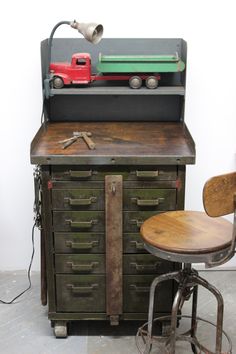 an old workbench with a toy truck on top and two stools next to it