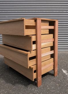 a large wooden drawer sitting on top of a cement floor next to a garage door