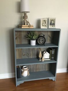 a blue book shelf with books and pictures on it