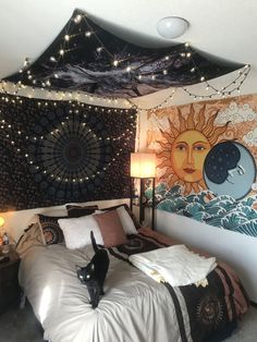 a cat is standing on the bed in front of a tapestry wall hanging above it