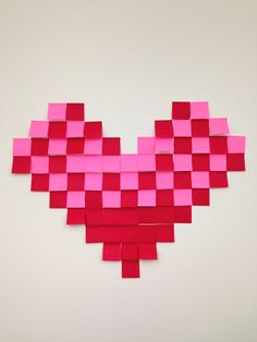 a heart made out of pink squares on a white wall