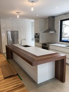 a large kitchen with an island counter next to a window