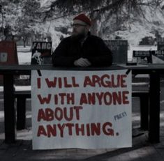 a man holding a sign that says i will agree with anyone about anything