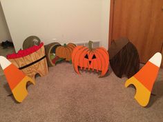 three pumpkins and two jack - o'- lanterns are sitting on the floor