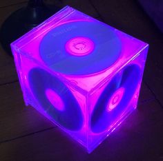 a purple and blue light up cube shaped object with speakers on it's sides