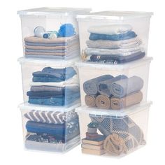 four clear storage containers with blue and white striped towels in the bottom one is filled with folded clothes