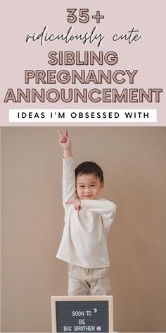 a little boy standing on top of a desk with his hands up in the air