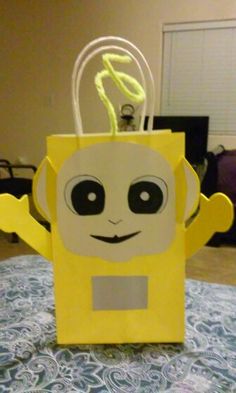 a yellow paper bag with a light bulb in the shape of a cartoon character on it