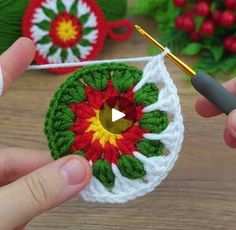 two crocheted christmas ornaments being worked on by someone using a knitting needle and yarn